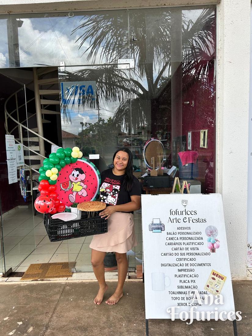 Ana Fofurices ao lado da plaquinha de serviços